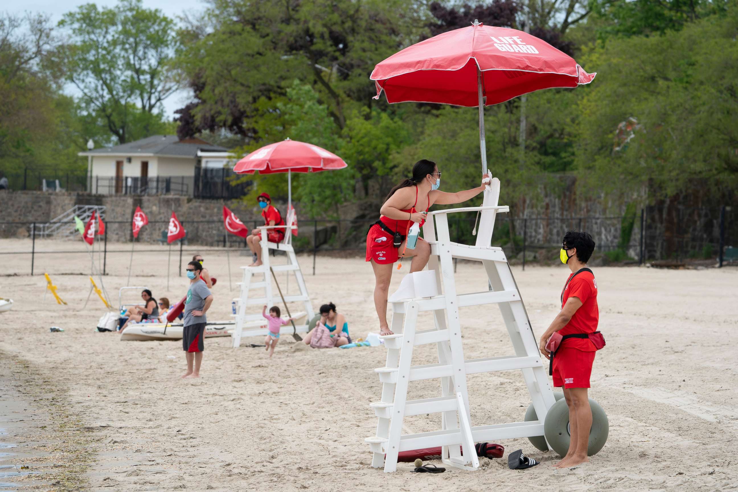 PHOTO: A lifeguard disinfects a guard chair at Rye Beach in Rye, N.Y., Friday, May 22, 2020, as guards, wearing face masks, take to their stands for Memorial Day weekend amid the coronavirus pandemic.