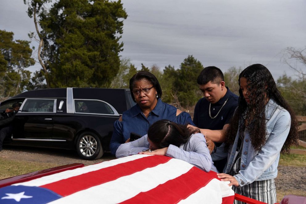 PHOTO: In this Jan. 26, 2021, file photo, a woman is comforted by the casket of her husband, who died from complications from COVID-19, in San Felipe, Texas.