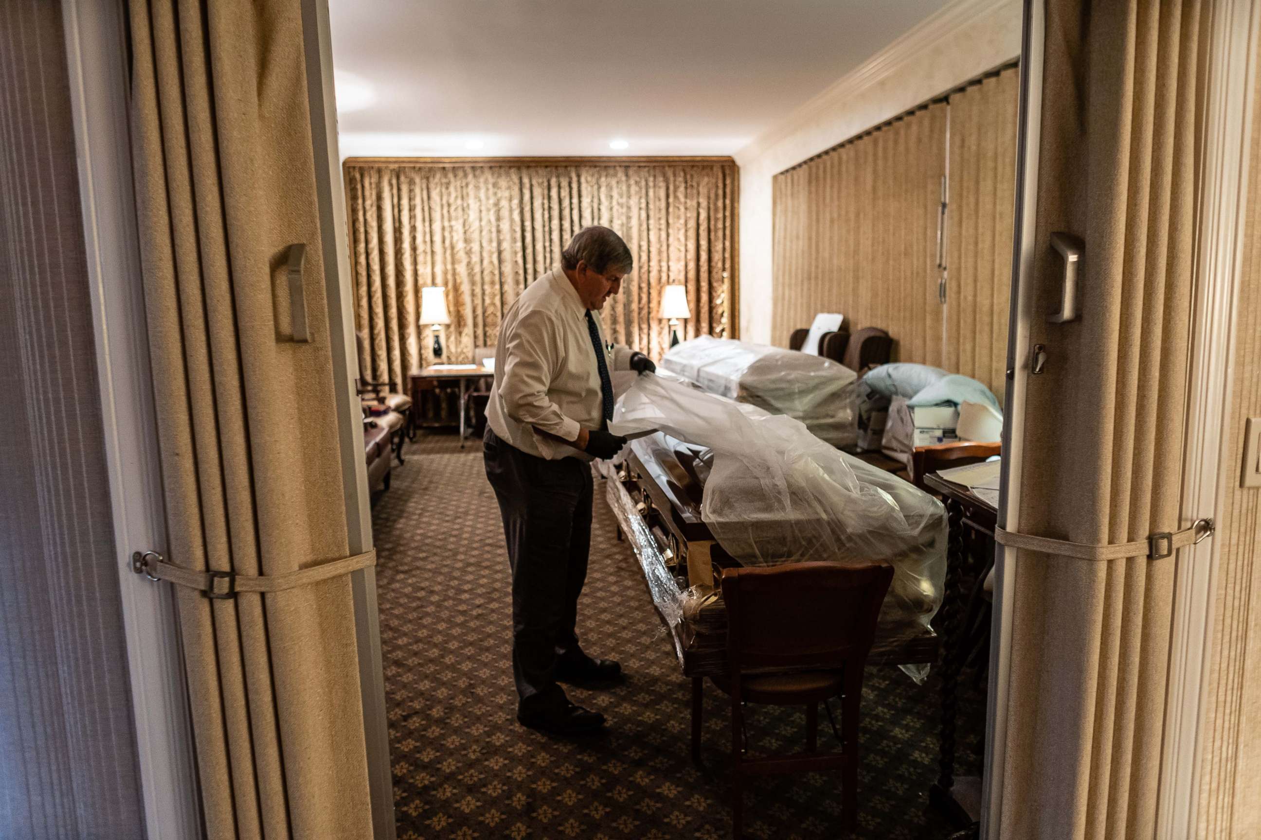 PHOTO: Funeral Director Joe Neufeld inventories the bodies of coronavirus victims bound for burial, in the main chapel of the Gerard J. Neufeld Funeral Home in Queens, New York, April 26, 2020.