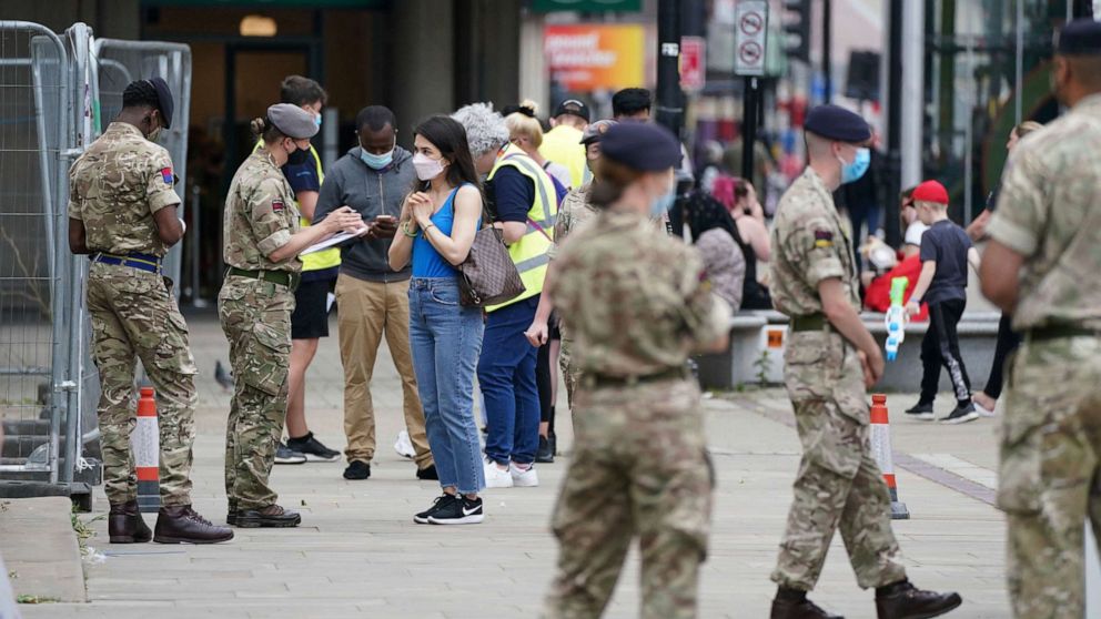 PHOTO: Members of the Armed Forces speak to people, outside a mobile COVID-19 vaccination center outside Bolton Town Hall, in Bolton, England, June 9, 2021, where case numbers of the Delta variant first identified in India have been relatively high.