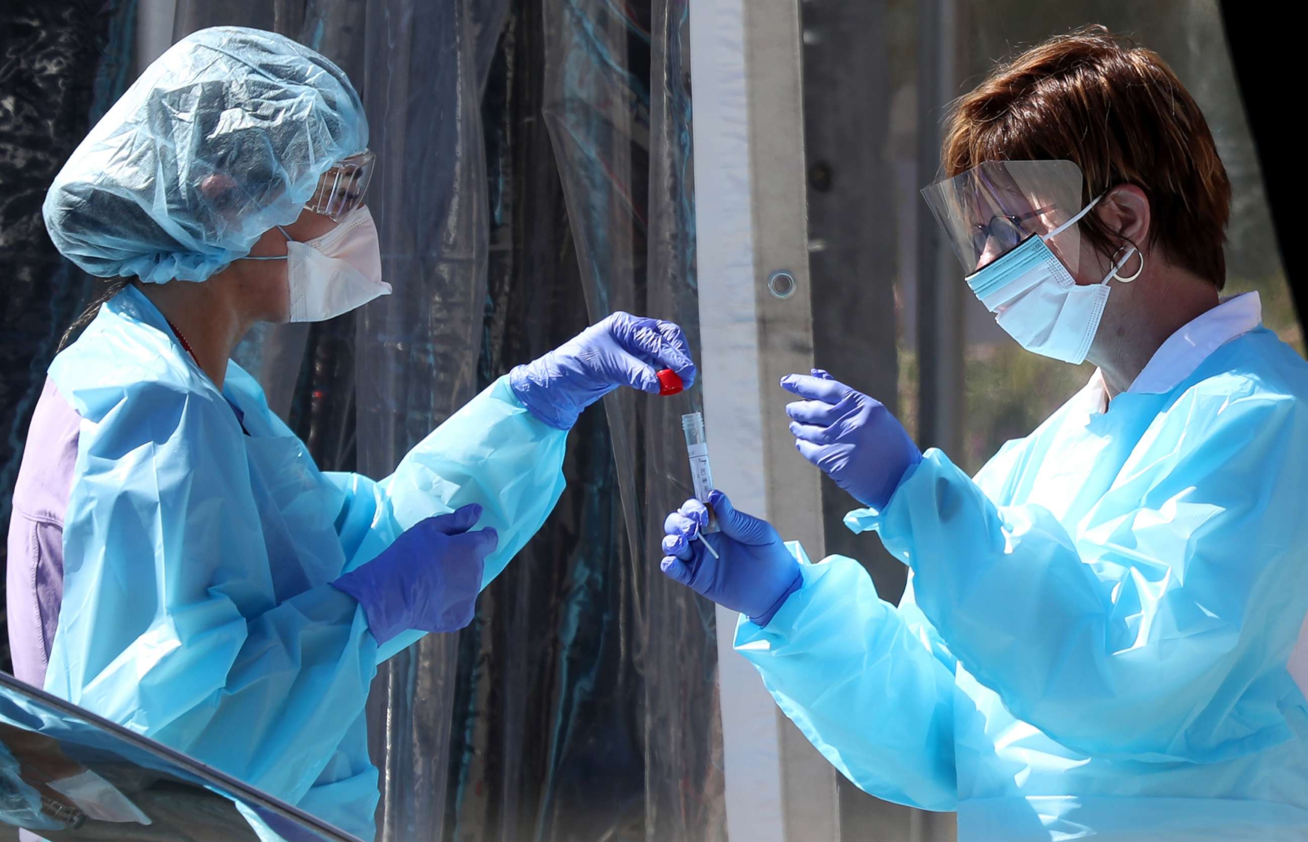 PHOTO: Medical personnel secure a sample from a person at a drive-thru Coronavirus COVID-19 testing station at a Kaiser Permanente facility, March 12, 2020 in San Francisco.