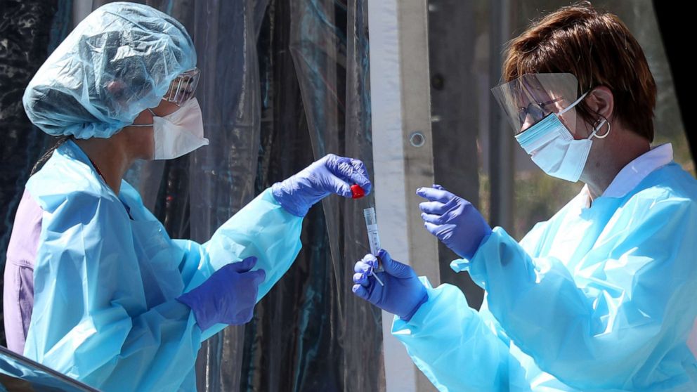 PHOTO: Medical personnel secure a sample from a person at a drive-thru Coronavirus COVID-19 testing station at a Kaiser Permanente facility, March 12, 2020 in San Francisco.