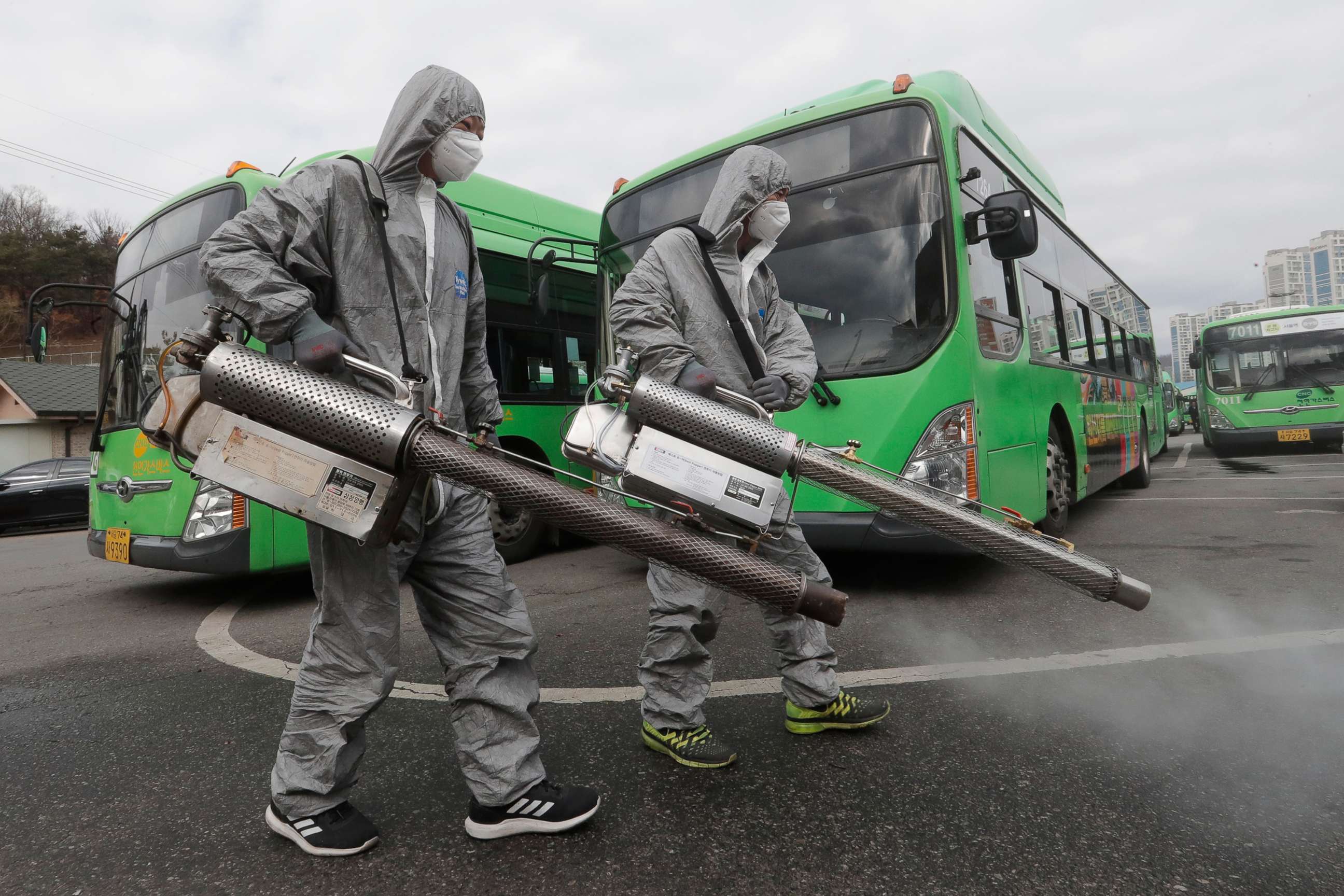PHOTO: Workers wearing protective suits spray disinfectant as a precaution against the coronavirus at a bus garage in Seoul, South Korea, Feb. 26, 2020. 