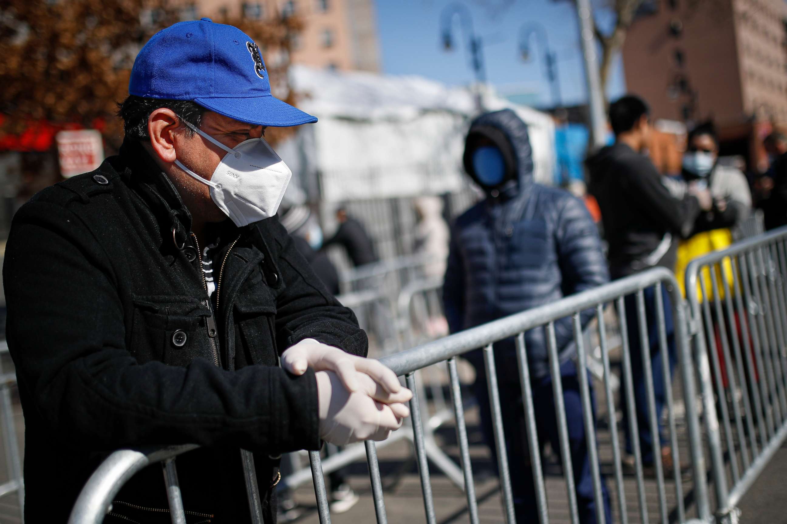 PHOTO: A patient wears a protective mask and gloves while waiting for COVID-19 testing outside Elmhurst Hospital Center, March 27, 2020, in New York.