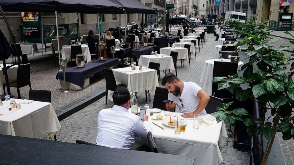 PHOTO: People eat at a mostly empty restaurant with tables on the street, in the financial district during the coronavirus pandemic in New York, Sept. 9, 2020. 