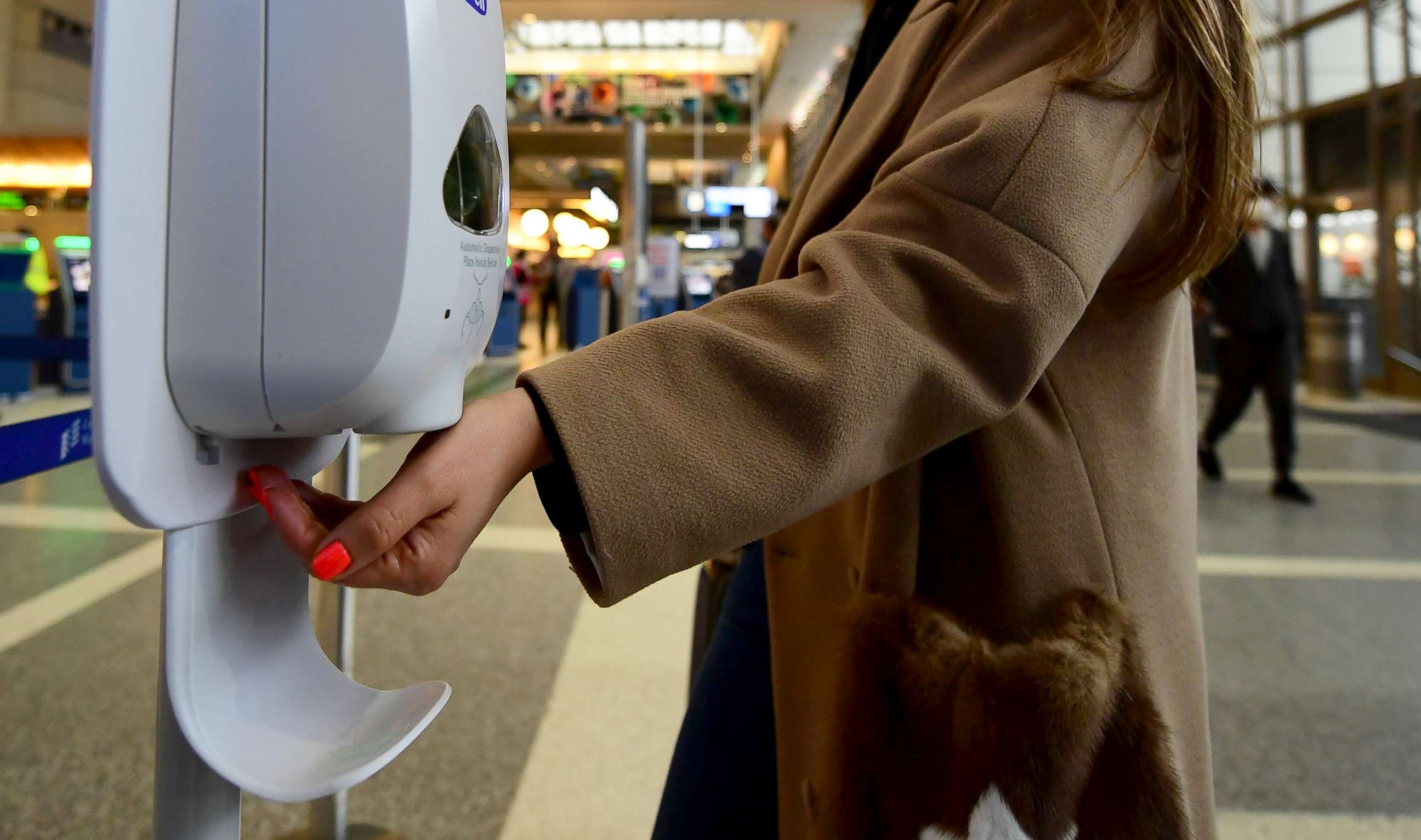 PHOTO: A woman uses hand sanitizer at Los Angeles International Airport, March 12, 2020, one day before a US flight travel ban hits 26 European countries amid ongoing precautions over the Coronavirus.