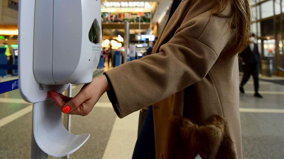 PHOTO: A woman uses hand sanitizer at Los Angeles International Airport, March 12, 2020, one day before a US flight travel ban hits 26 European countries amid ongoing precautions over the Coronavirus.