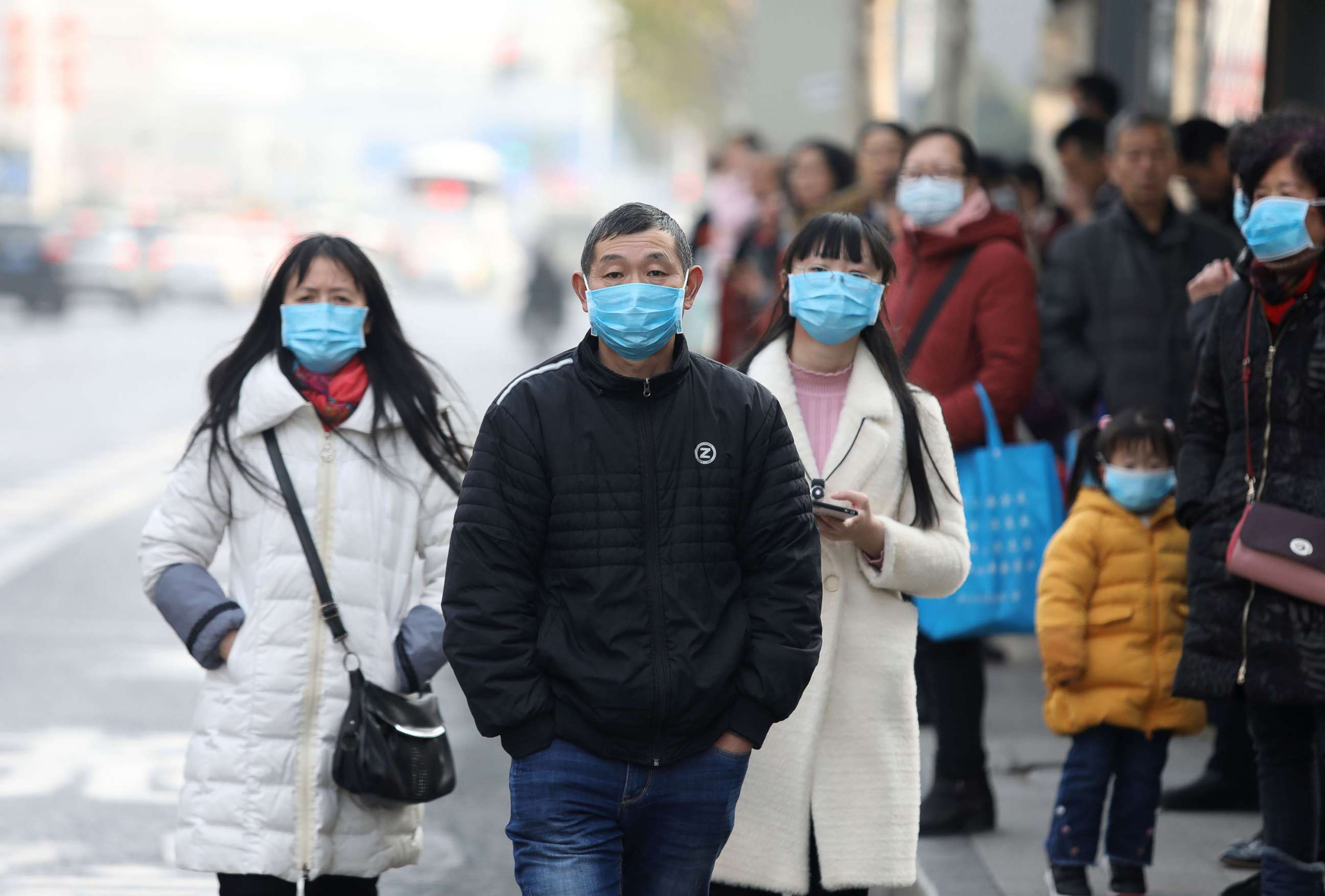 PHOTO: Chinese residents wear masks near the closed Huanan Seafood Wholesale Market, which has been linked to cases of a new strain of Coronavirus identified as the cause of the pneumonia outbreak in Wuhan, Hubei province, China, Jan. 20, 2020.