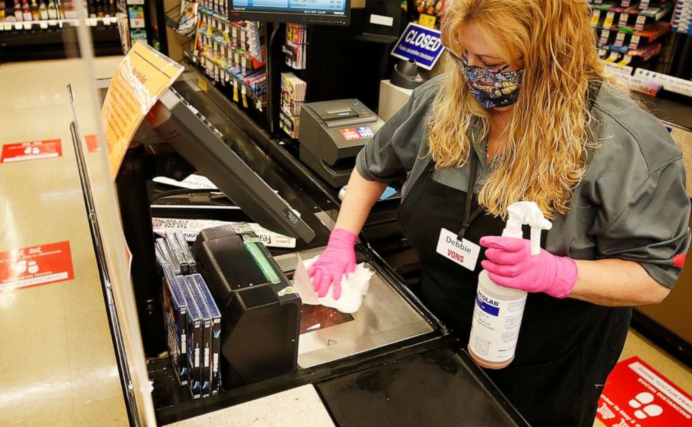 PHOTO: A grocery store cashier cleans and sanitizes her checkout lane before opening in Torrance, Calif., April 27, 2020.