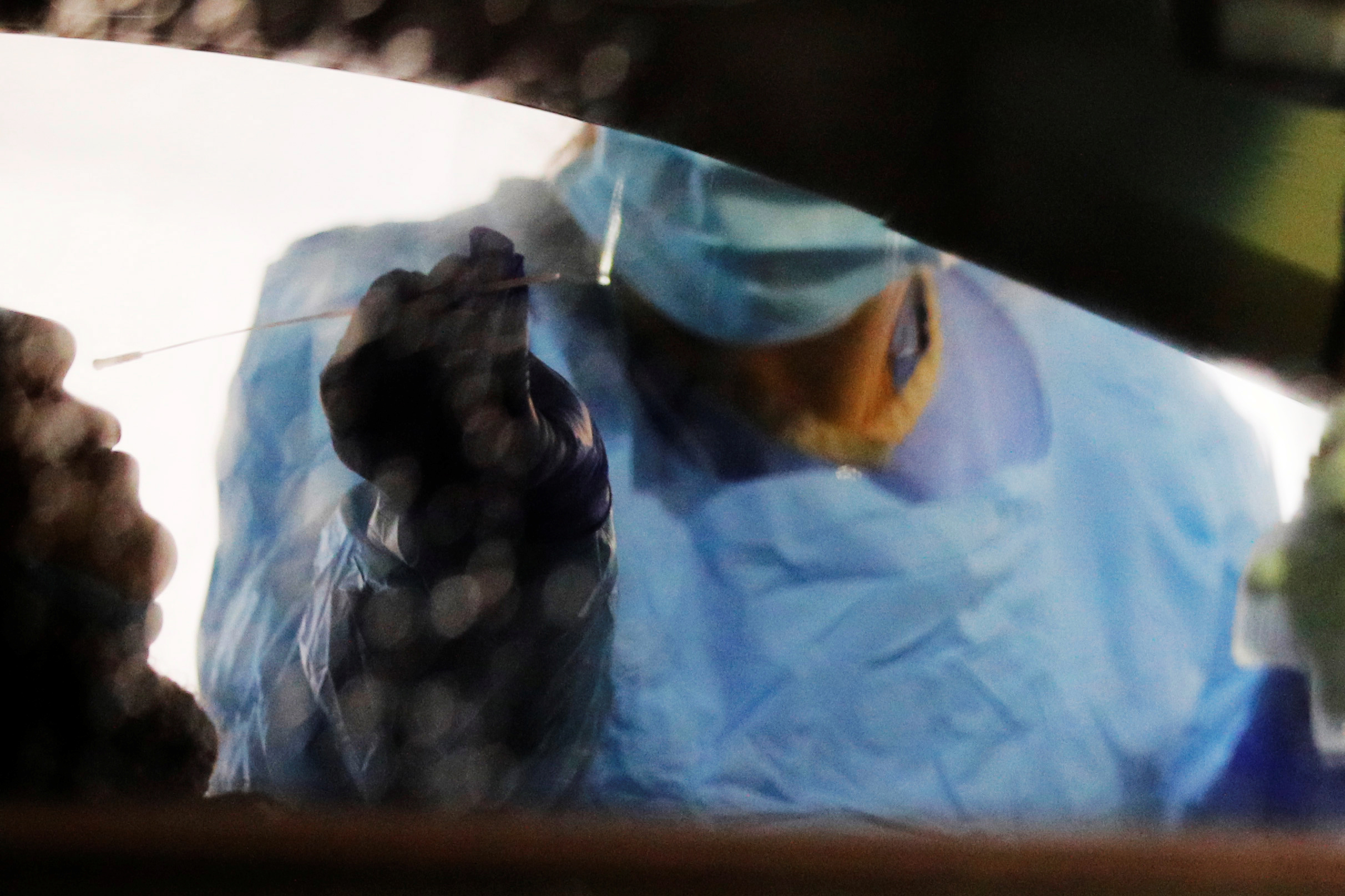 PHOTO: Medical personnel swab a driver's nose at a drive-through testing site for coronavirus for employees at UW Medical Center Northwest in Seattle, March 13, 2020.  