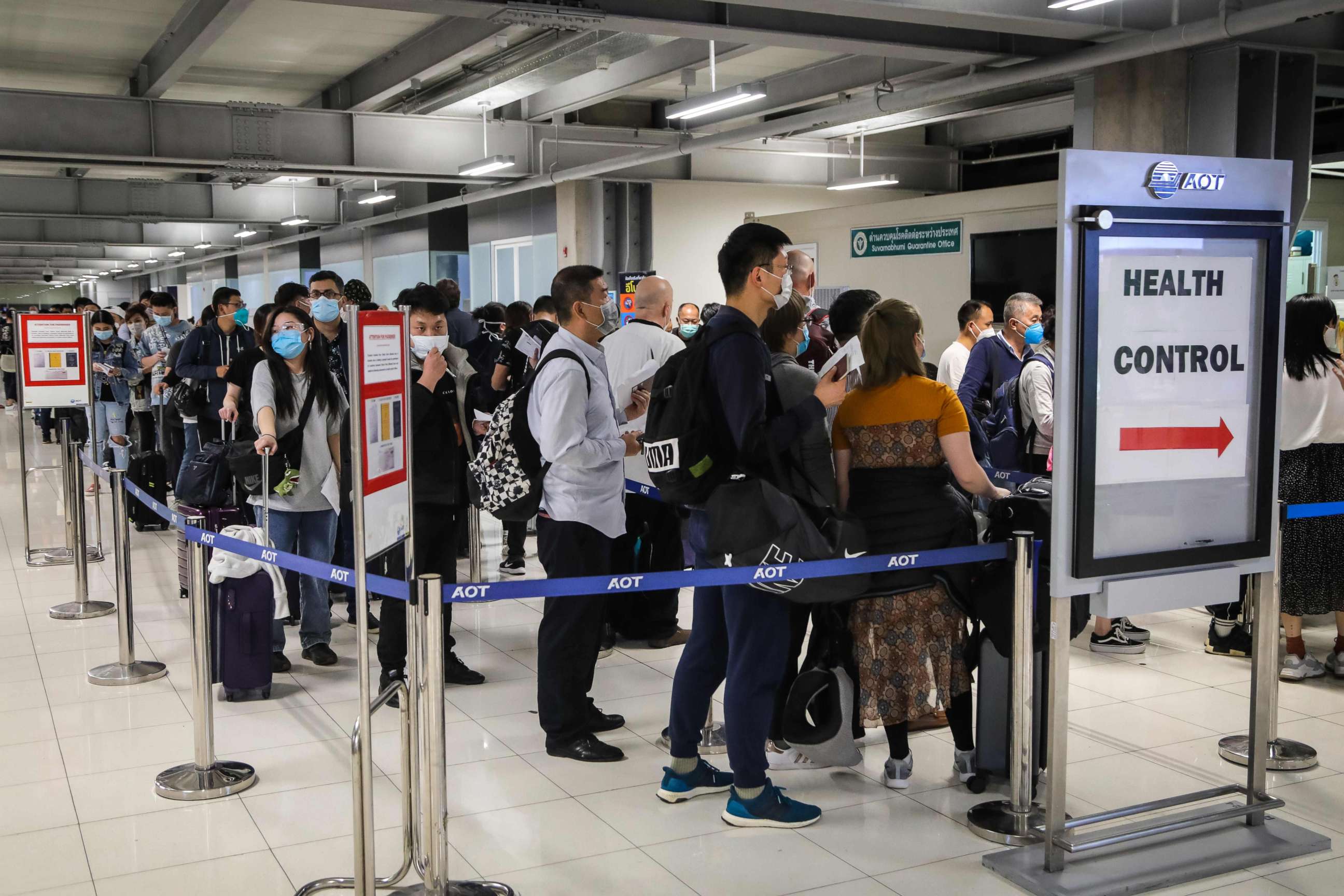 PHOTO: Passengers line up to have their health assessed at a checkpoint for people flying in from a list of countries and territories as a precautionary measure against the spread of coronavirus at Suvarnabhumi Airport in Bangkok on March 9, 2020. 