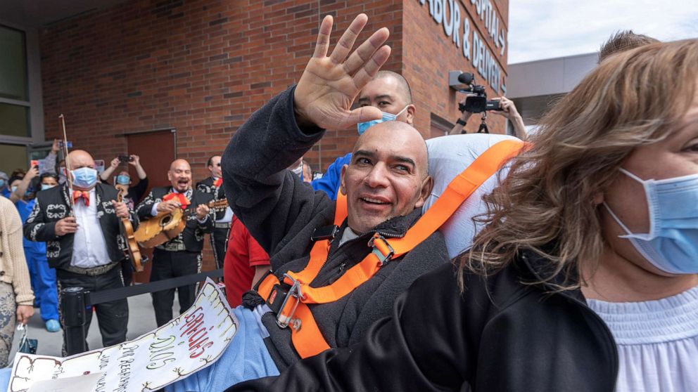 PHOTO: Hector Calderon, joined by his wife, waves to well-wishers as a Mariachi band plays as he's discharged from Kaiser Permanente Westside Medical Center in Hillsboro, Ore., May 4, 2020.