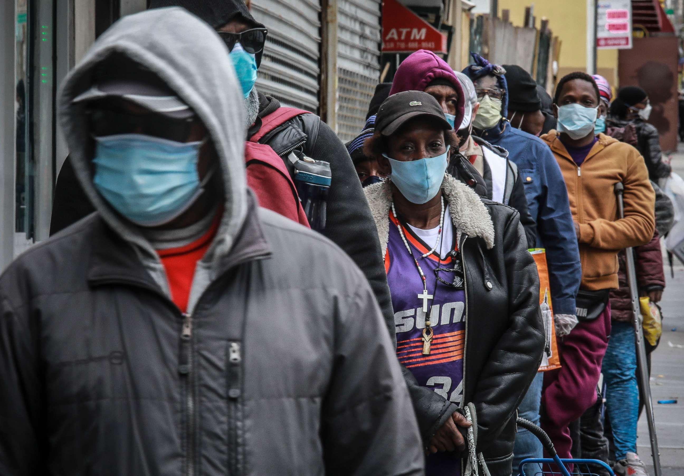 PHOTO: In this April 18, 2020, file photo, people wait for a distribution of masks and food from the Rev. Al Sharpton in the Harlem neighborhood of New York.