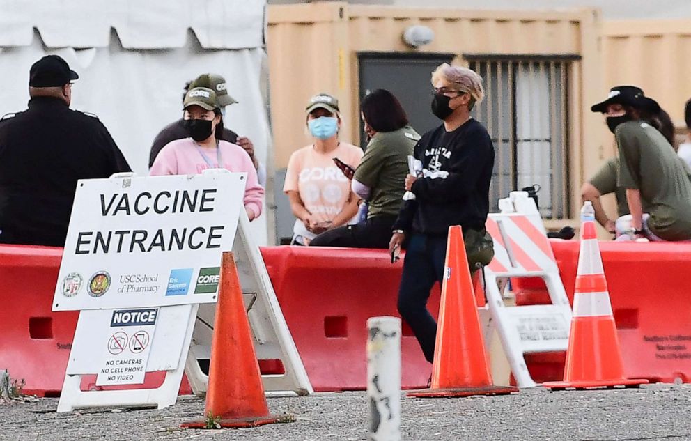 PHOTO: People wearing face masks outdoors are seen at a COVID-19 vaccination site in Los Angeles, California, on July 6, 2021.
