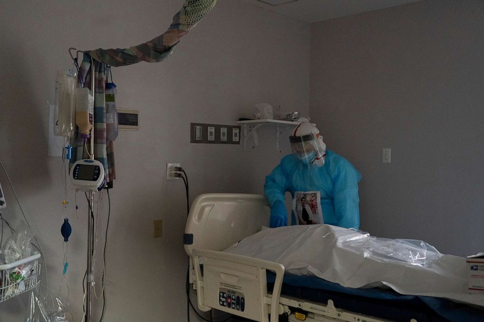 PHOTO: Medical staff member Gabriel Cervera Rodoriguez stands and takes a moment by a deceased patient wrapped in a body bag in the COVID-19 intensive care unit (ICU) at the United Memorial Medical Center, Dec. 11, 2020, in Houston.