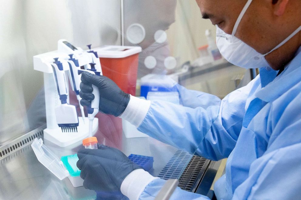 PHOTO: UCSF-Abbott Viral Diagnostics and Discovery Center lab director Dr. Charles Chiu demonstrates the process of extracting samples of COVID-19 for sequencing while working in his lab in San Francisco, Calif., Jan. 5, 2021.