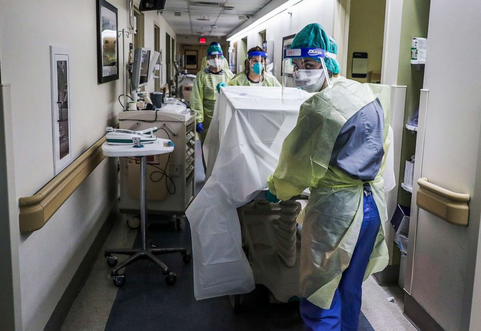 PHOTO: Lead RN Brynn Chevalier pushes a gurney down the COVID-19 floor at the West Roxbury VA Medical Center, as they transport a recently deceased patient out of the ward at West Roxbury VA Medical Center in Boston, Jan. 13, 2021. 