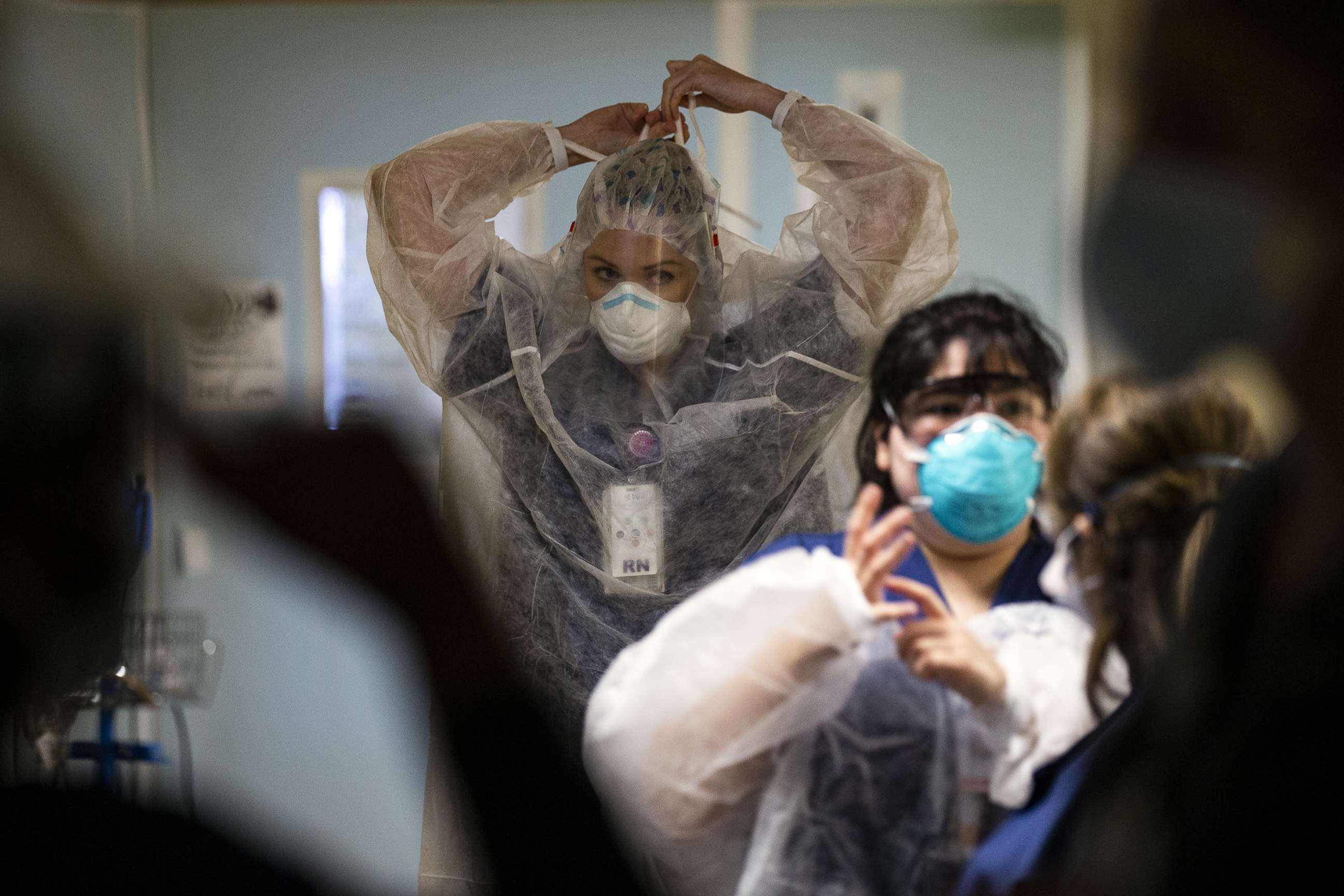 PHOTO: Caregivers put on PPE to enter a COVID-19 patient's room in the ICU of the Sharp Coronado Hospital, amid coronavirus pandemic in Coronado, west of San Diego, Calif., Jan. 20, 2021. 