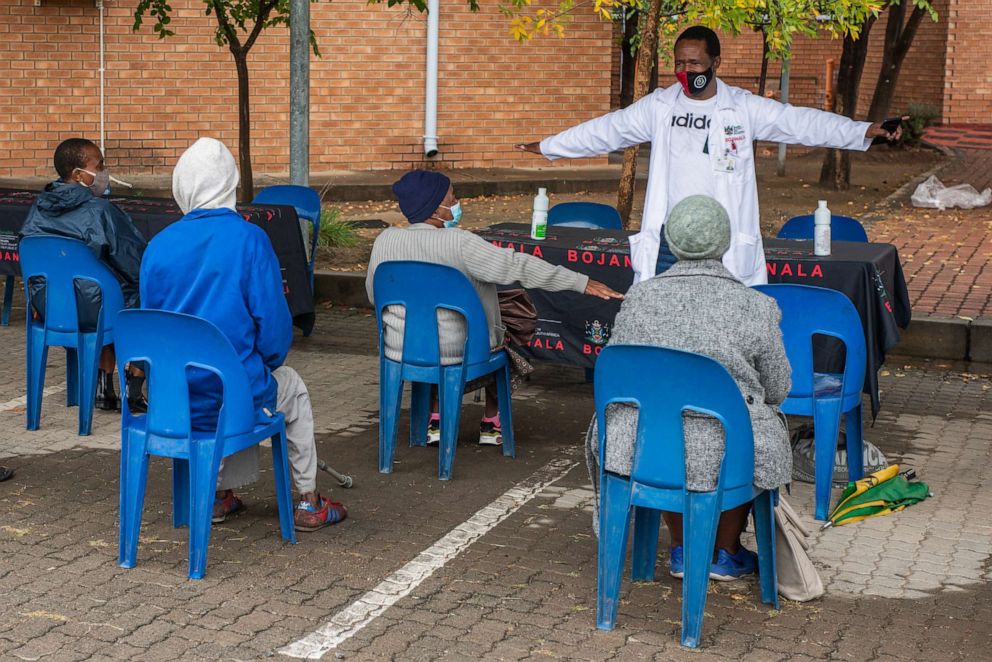 PHOTO: A health worker demonstrates social distance to elderly residents queue as they wait to register for the Covid-19 vaccination program outside the Bonang Community Health Centre, in Brits, South Africa,, April 30, 2021. 