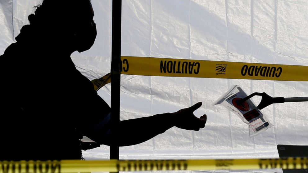 PHOTO: A woman receives a COVID-19 testing kit at a regional pop-up walk-up testing site in Baldwin Park, Calif., Dec. 21, 2020.