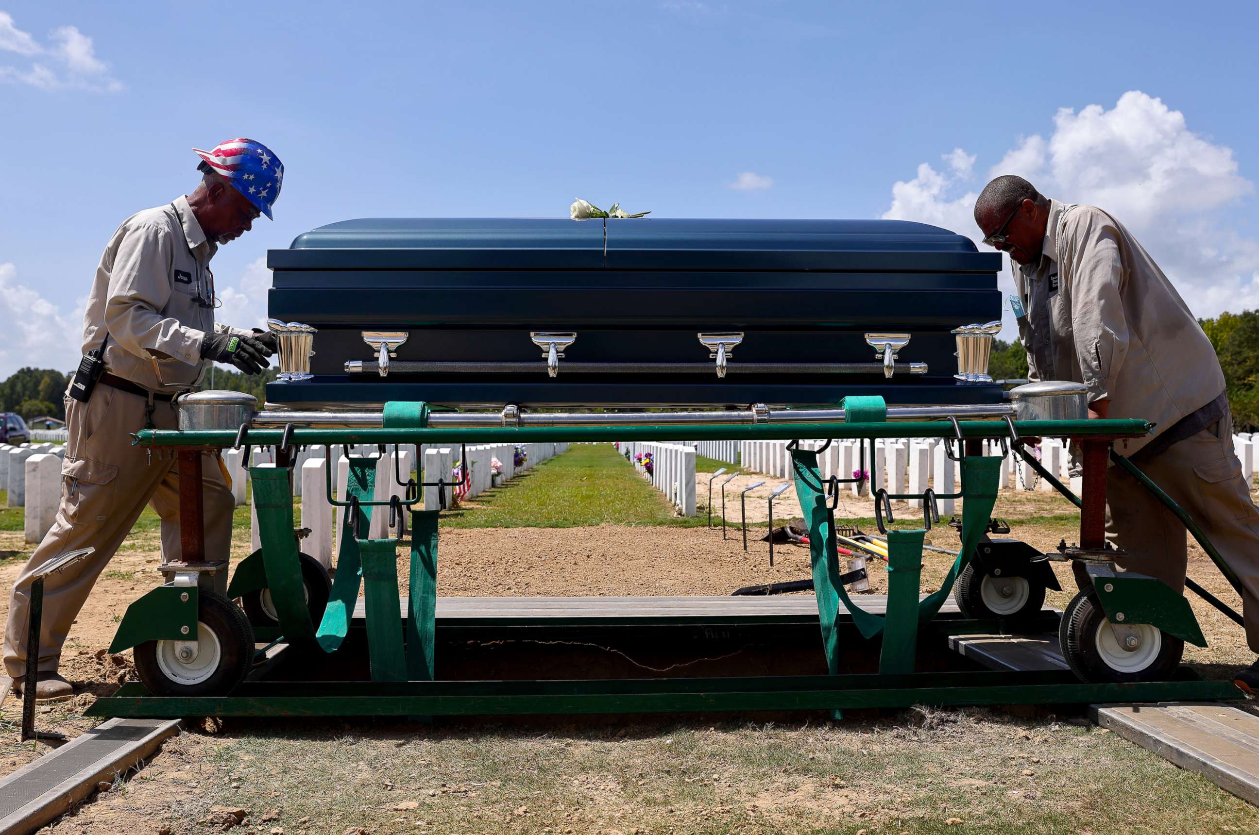 PHOTO: In this Aug. 20, 2021, file photo, caretakers prepare to inter the casket of a person who passed away from complications caused by COVID-19, at Louisiana National Cemetery in Zachary, La. 