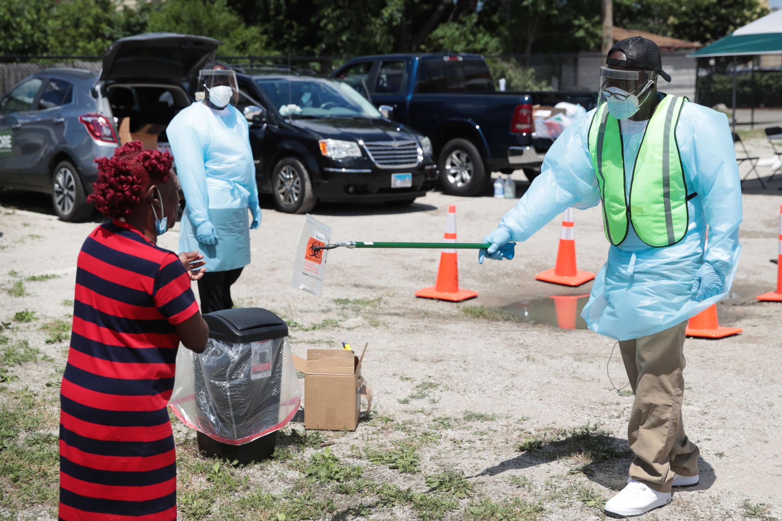 PHOTO: Workers help residents process a COVID-19 self-test at a mobile COVID-19 testing site set up in the Austin neighborhood of Chicago, June 23, 2020.
