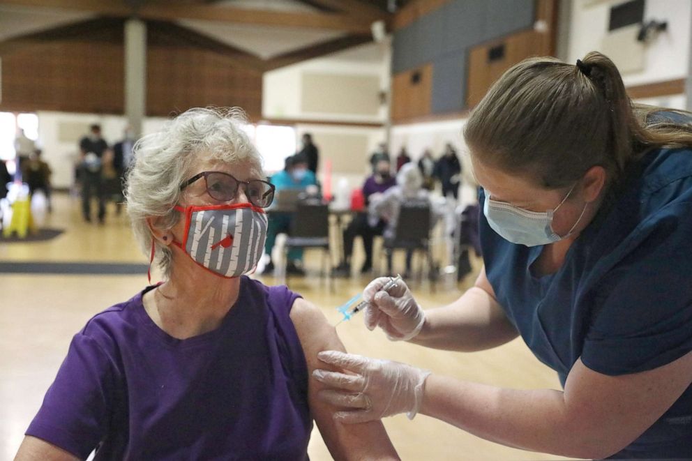 PHOTO: Marna McKenzie of Sebastapol, 90, receives a Pfizer COVID-19 vaccine from Lacey Ernst, event operations administrator, during a COVID-19  vaccination clinic for seniors at the Rohnert Park Community Center on Jan. 27, 2021 in Rohnert Park, Calif. 