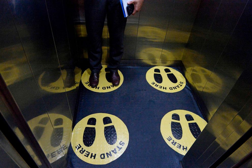 PHOTO: A customer uses an elevator while maintaining social distancing as a preventive measure against the COVID-19 coronavirus, in Hyderabad, India, June 12, 2020.