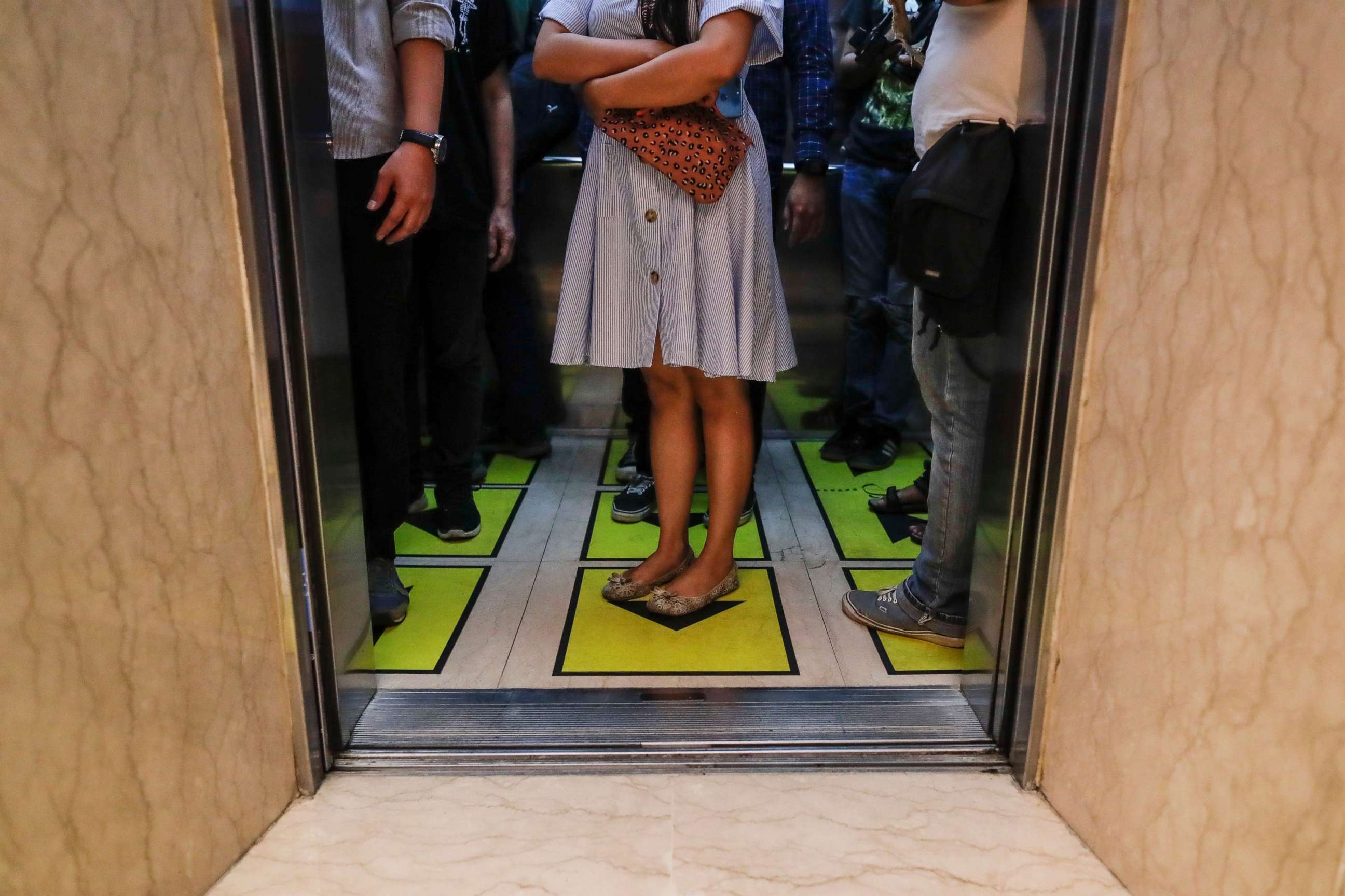 PHOTO: Workers stand on social distancing marks inside an elevator of the Senayan City shopping mall in Jakarta, Indonesia, June 9, 2020.