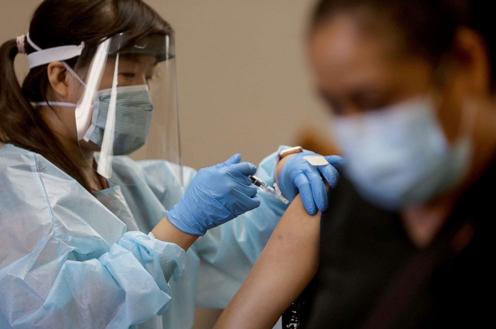PHOTO: A nurse administers a flu vaccination shot at a free clinic held at a local library on Oct.14, 2020, in Lakewood, Calif.