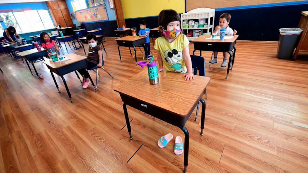 PHOTO: Children in a pre-school class wear masks and sit at desks spaced apart as per coronavirus guidelines during summer school sessions at Happy Day School in Monterey Park, Calif., July 9, 2020. 