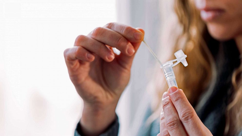 PHOTO: FILE - A woman placing swab into the antigen test extraction tube