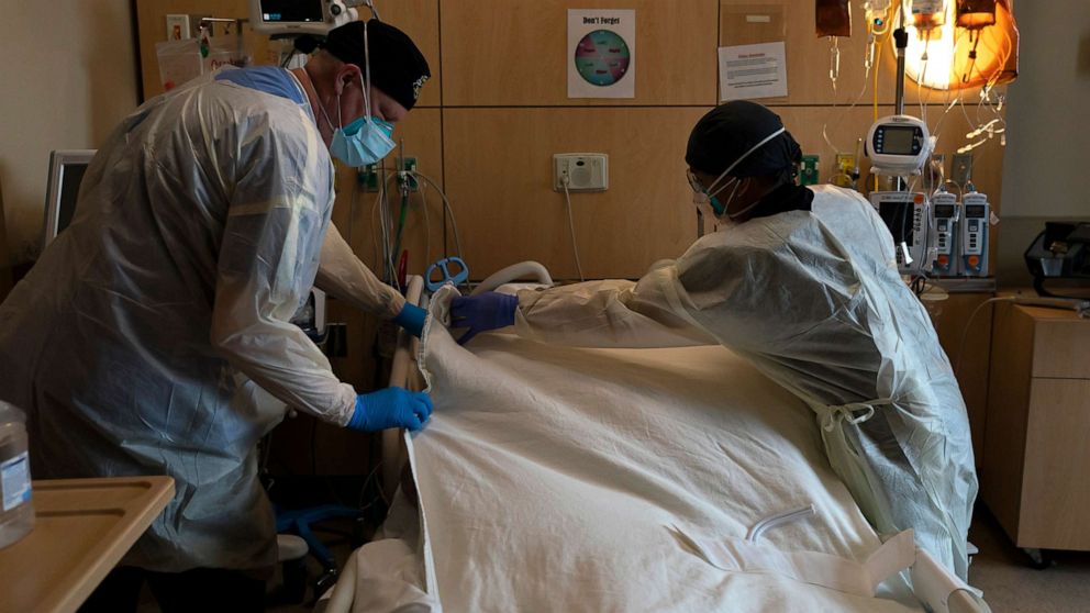 PHOTO: Hospital workers cover a body of a COVID-19 patient with a sheet at Providence Holy Cross Medical Center in Los Angeles, Dec. 14, 2021.