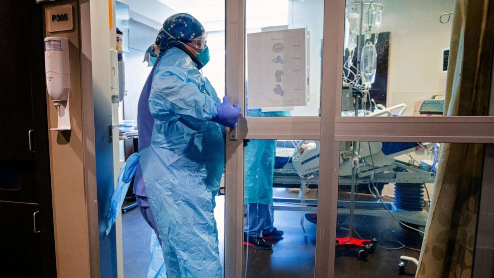 PHOTO: A nurse enters a room in the COVID ICU to administer treatment to a patient at SSM Health St. Anthony Hospital in Oklahoma City, on Aug. 5, 2022. covid