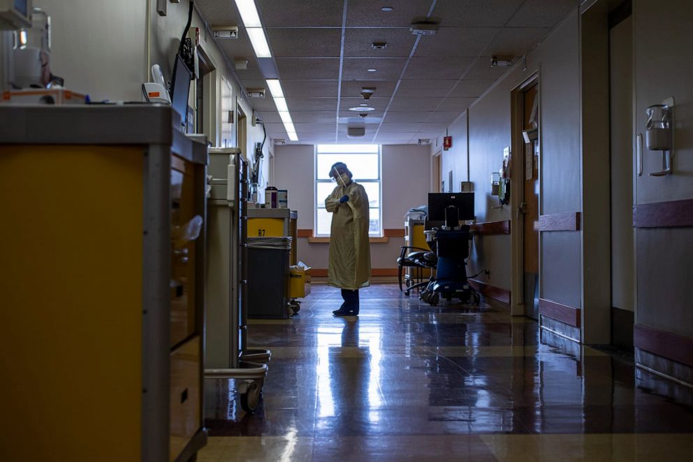 PHOTO: A nurse puts on personal protective equipment as she prepares to enter a COVID-19 patient's room inside IU Health Methodist Hospital in Indianapolis, April, 2020.