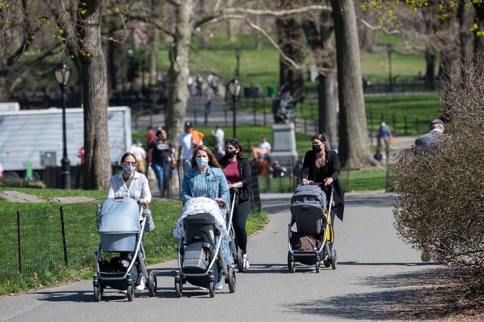 PHOTO: In this April 8, 2021, file photo, women wearing masks push strollers in Central Park in New York.