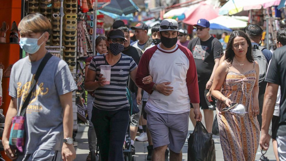 PHOTO: Shoppers, some wearing masks, visit in a market, July 14, 2022 in Los Angeles, during the COVID-19 pandemic.