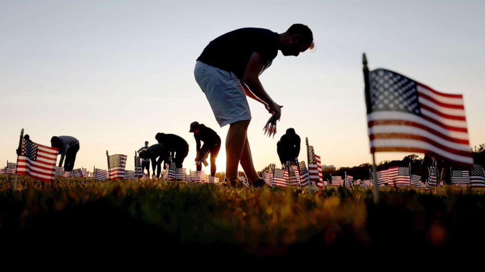 PHOTO:  Volunteers with the COVID Memorial Project install 20,000 American flags on the National Mall in Washington as the United States crosses the 200,000 lives lost in the COVID-19 pandemic September 20, 2020.