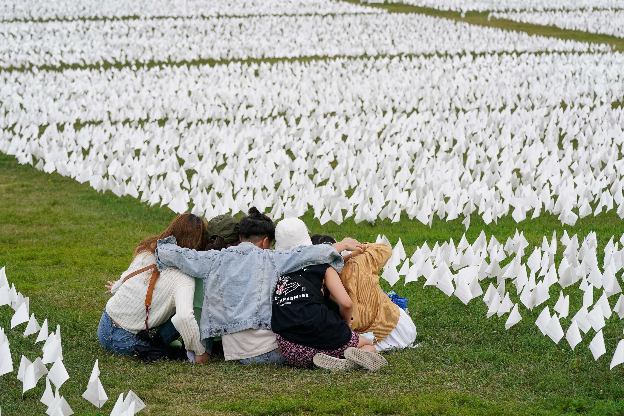 PHOTO: In this Sept. 21, 2021, file photo, visitors sit among white flags that are part of artist Suzanne Brennan Firstenberg's "In America: Remember," a temporary art installation to commemorate Americans who have died of COVID-19, in Washington, D.C.