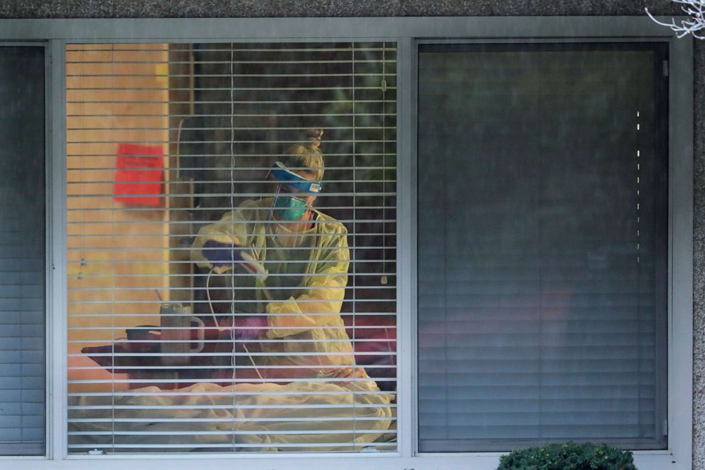 PHOTO: A nurse works in the room of a patient who has tested positive for the COVID-19 coronavirus at the Life Care Center in Kirkland, Wash., March 13, 2020.