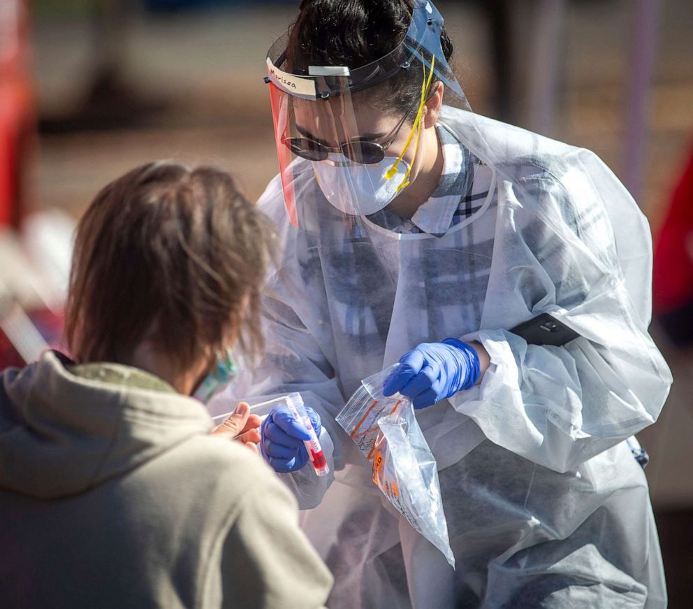 PHOTO: Marissa Gallegos with Medical Teams Northwest takes a swab from a person  while administering COVID-19 testing at the Lane County Fairgrounds in Eugene, Ore., Oct. 8, 2020.