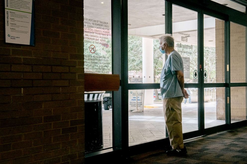 PHOTO: A medical physician stares outside of an entrance at the Houston Methodist Hospital, July 16, 2021 in Houston, Texas.