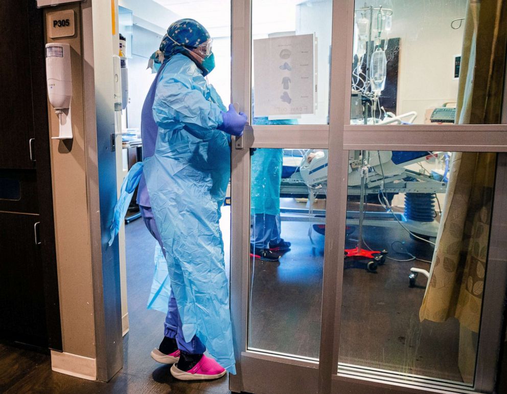PHOTO: A nurse enters a room Tuesday in the COVID ICU to administer treatment to a patient at SSM Health St. Anthony Hospital.CP choice 2
