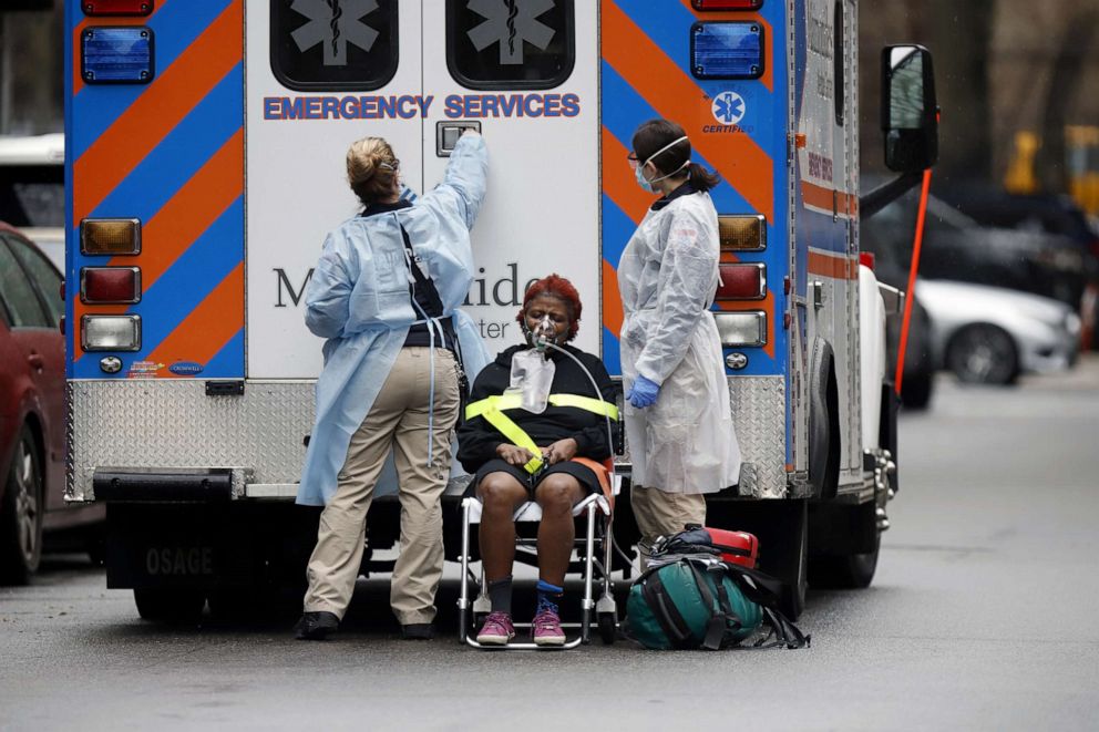 PHOTO: Emergency Medical Technicians (EMT) wearing protective gears wheel a sick patient to a waiting ambulance during the outbreak of coronavirus disease (COVID-19) in, New York, March 28, 2020. 