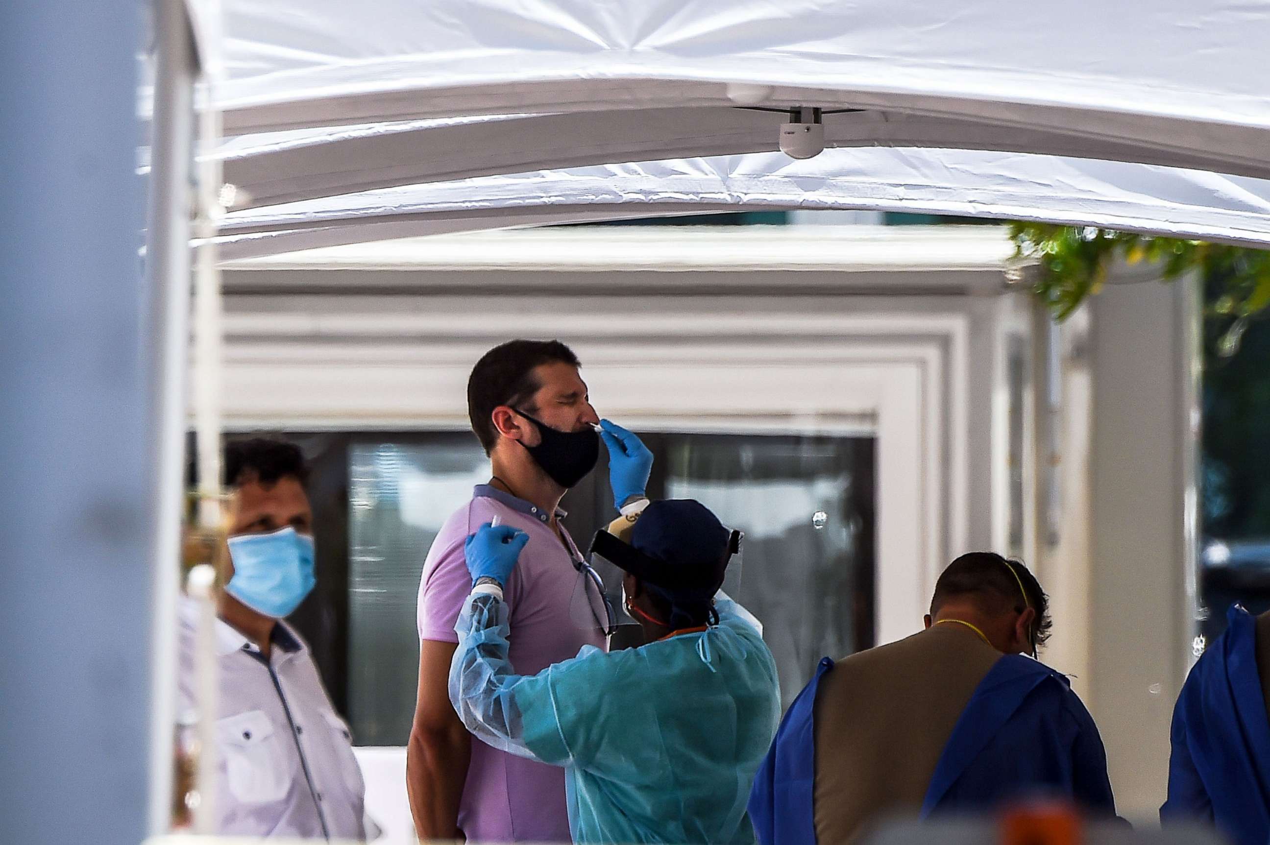 PHOTO: In this June 24, 2020, file photo, a medical personnel member takes samples on a man at a Covid-19 testing site in Miami Beach, Fla.