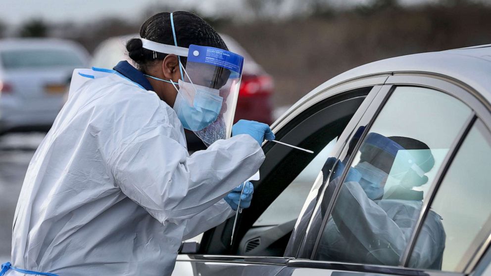 PHOTO: Nurse practitioner Deborah Beauplan administers a COVID-19 swab test at a drive-thru testing site at Smith Point Park, Dec. 19, 2020, in Shirley, N.Y.