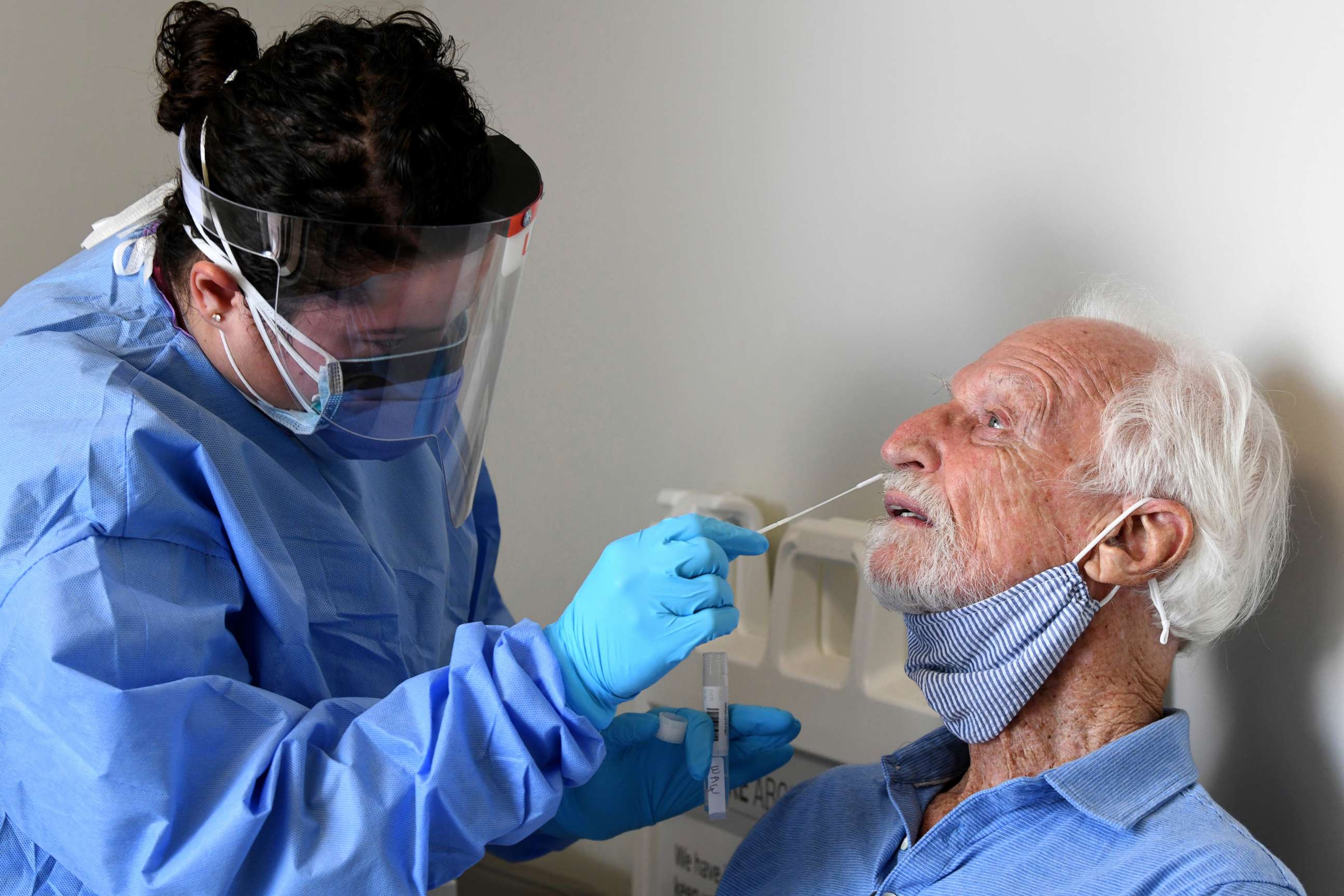 PHOTO: National Institutes of Health-funded Moderna COVID-19 vaccine study participant William Webb, right, gets a COVID-19 nose swab test by University of Miami Miller School of Medicine nurse Loreta Padron, Sept. 2, 2020, in Miami.