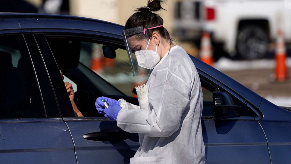 PHOTO: A tester prepares to administer a swab test at a drive-in COVID-19 testing site, Oct. 27, 2020, in Federal Heights, Colo.
