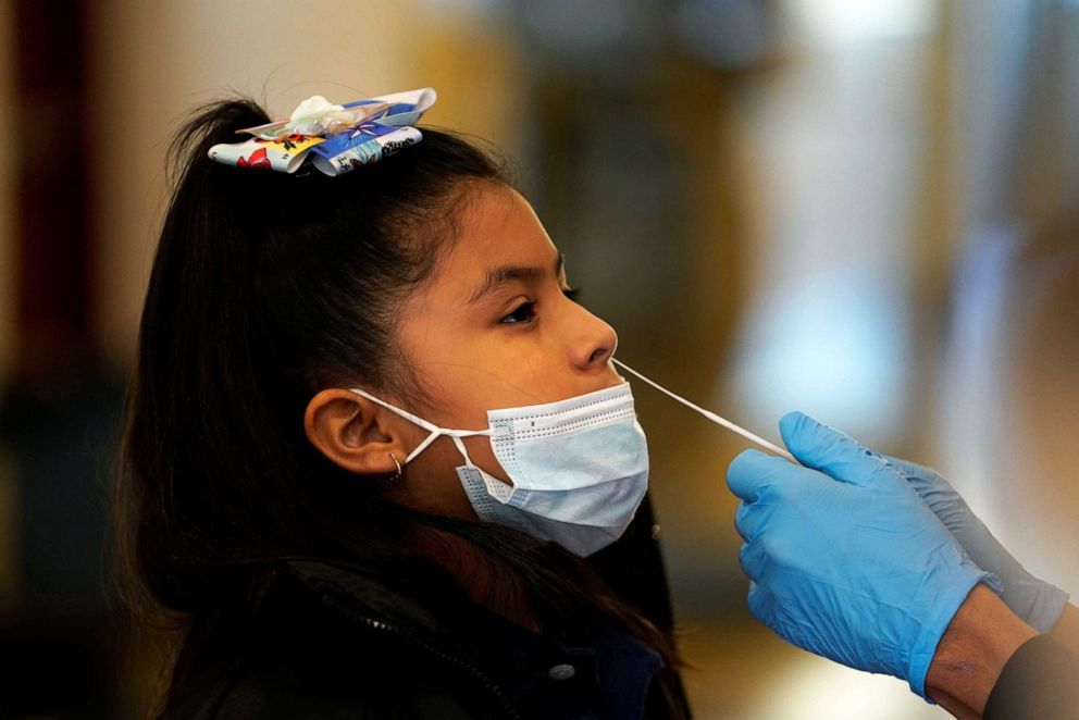 PHOTO: An 8-year-old girl is tested for COVID-19 after being exposed at school at the Tower Theatre in Oklahoma City, on Jan. 11, 2022.