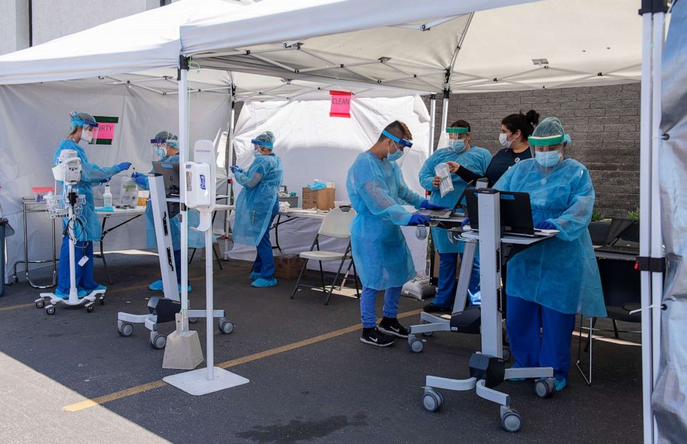 PHOTO: Medical personnel from AltaMed collect COVID-19 tests from drive-through patients at their clinic on Bristol Street in Santa Ana, Calif., April 21, 2020. 